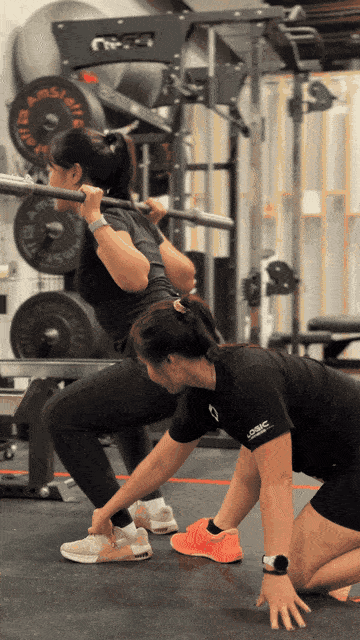 Coach giving 1:1 squat coaching to a client